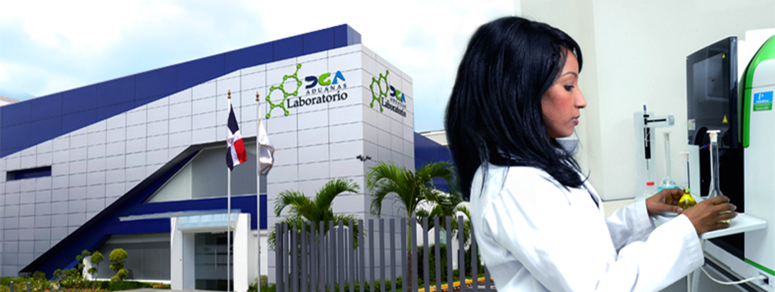 Imagen del laboratorio de la Dirección General de Aduanas (DGA) con una profesional realizando un análisis químico en el interior del laboratorio. Al fondo se observa el moderno edificio del laboratorio con el logo de DGA y las banderas de la República Dominicana y de la institución ondeando en el exterior, rodeado de palmeras y un entorno bien cuidado