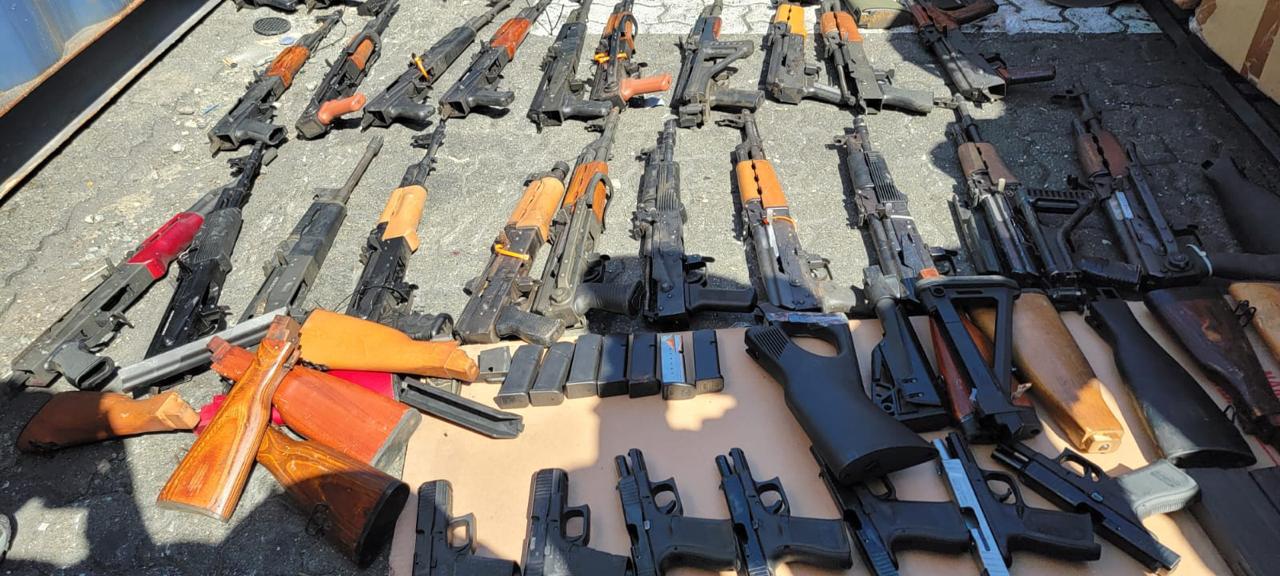 Muchas armas de fuego que fueron incautadas organizadas en el suelo